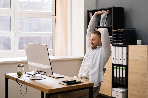 Stretch Exercise At Office Desk. Businessman At Computer