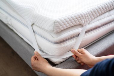 Mattress Topper Being Laid On Top Of The Bed clipart