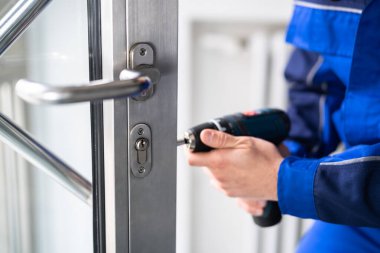 Locksmith Man Repairing And Changing Metal Door Lock clipart