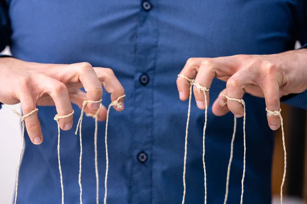 Manipulating Marionette Puppet Strings By Hand. Business Power