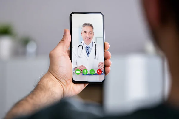 Hombre Teniendo Vídeo Chat Con Médico Teléfono Casa —  Fotos de Stock