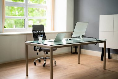 Ofis odası ve bilgisayar ekranlı mobilyalar.