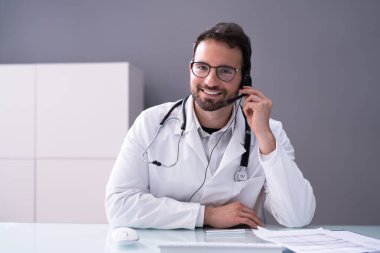 Kulaklıklı mutlu hastane resepsiyonisti. Doktor Çağrı Konferansı Portresi