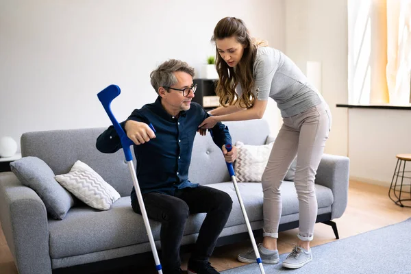 Donna Aiutare Ferito Handicappato Uomo Con Stampelle — Foto Stock