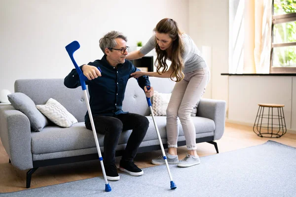Mujer Ayudando Hombre Discapacitado Lesionado Con Muletas —  Fotos de Stock