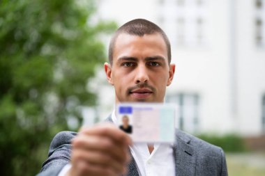 Mübaşicra ev girişinde kimlik gösteren ayakta