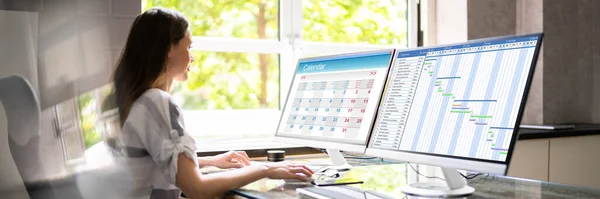 Frau Plant Kalender Auf Mehreren Computerbildschirmen — Stockfoto