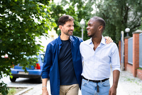 Gay Couple Dating In Jeans. Walking On Street In City