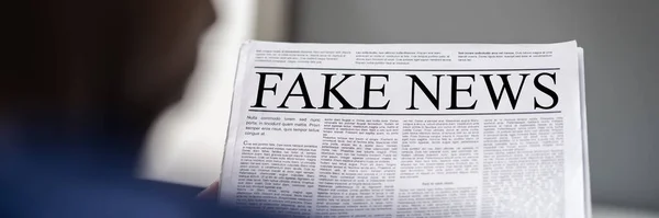 アフリカ人男性が偽のニュースを読む 新聞の見出し — ストック写真