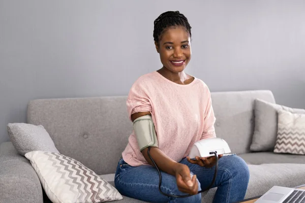 African Patient Doing Blood Pressure Check At Home