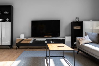 Oturma odasında ahşap döşemeli televizyon mobilyaları.