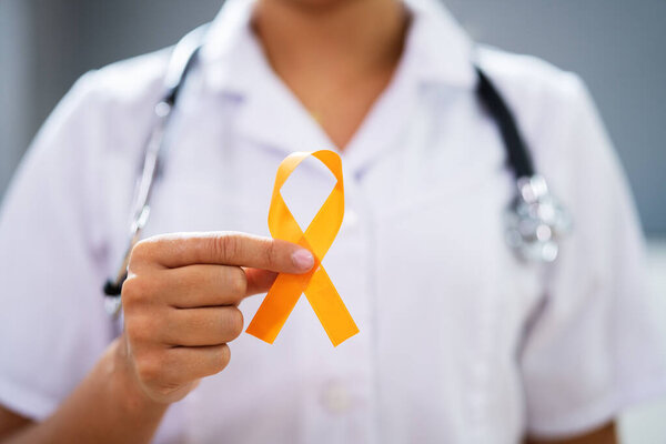Female Doctor's Hand With Ribbon Showing Uterine Cancer Awareness