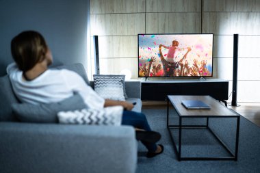 Televizyon izleyen bir kadın. Sinema ve Televizyonun tadını çıkarıyorum.
