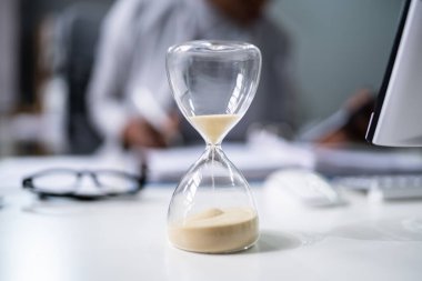 Geç gelen fatura ve fatura teslim tarihi. Masada kum saati var.