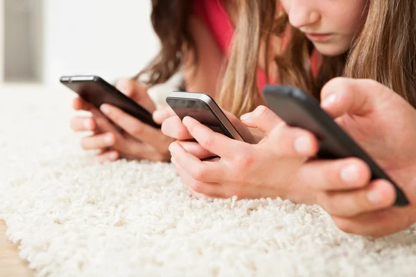 Familia usando teléfonos inteligentes — Foto de Stock