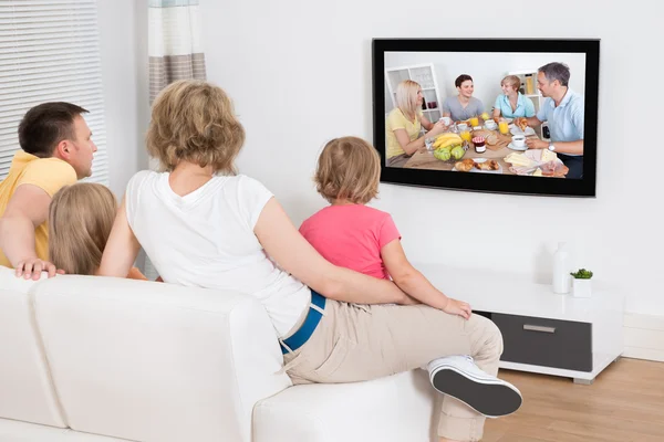 Família jovem assistindo TV juntos — Fotografia de Stock