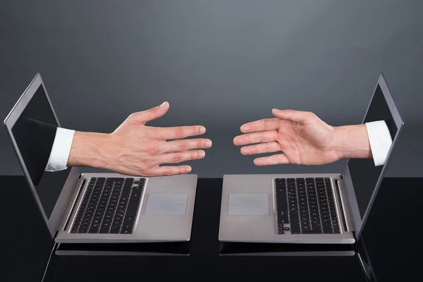 Die Hände der Geschäftsleute, die von Laptops ausgehen, die den Deal repräsentieren — Stockfoto
