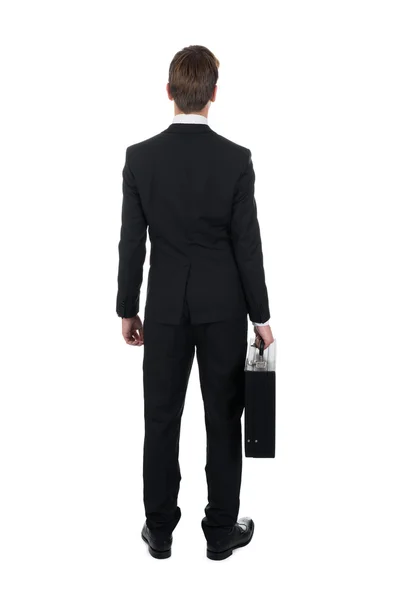 ブリーフケースを運ぶビジネスマンの背面図 — ストック写真