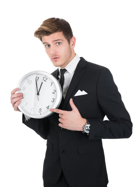 Portrait d'homme d'affaires pointant vers l'horloge — Photo