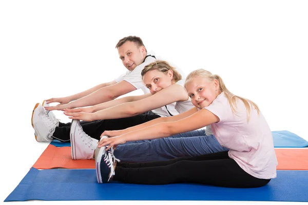 Ung familj göra stretchingövningar — Stockfoto
