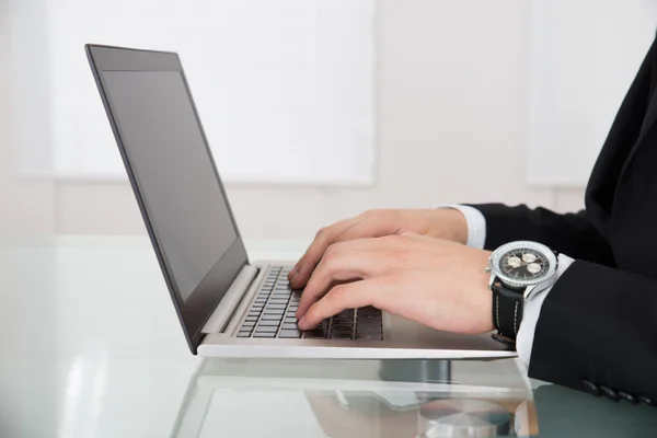 Affärsman som arbetar på laptop på skrivbordet — Stockfoto