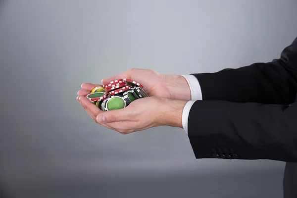 Руки бизнесмена держат фишки для покера в руках — стоковое фото