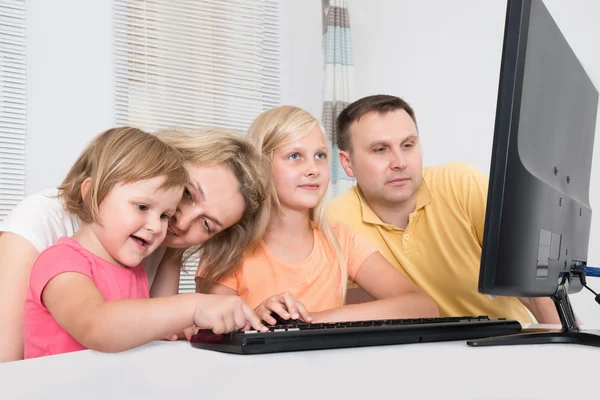 Junge Familie nutzt gemeinsam Computer — Stockfoto