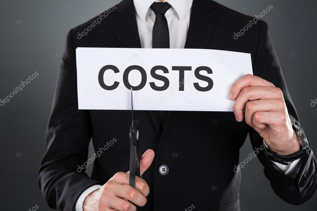 Businessman Cutting The Word Costs On Paper With Scissors