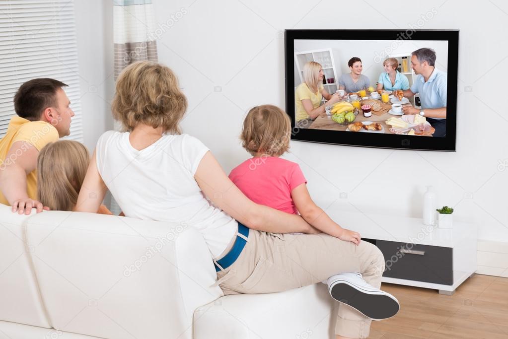 Young Family Watching  TV  Together  Stock Photo 