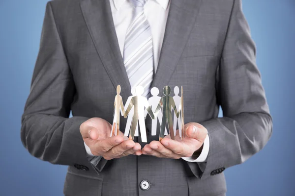 Businessman holding paper people — Stock Photo, Image