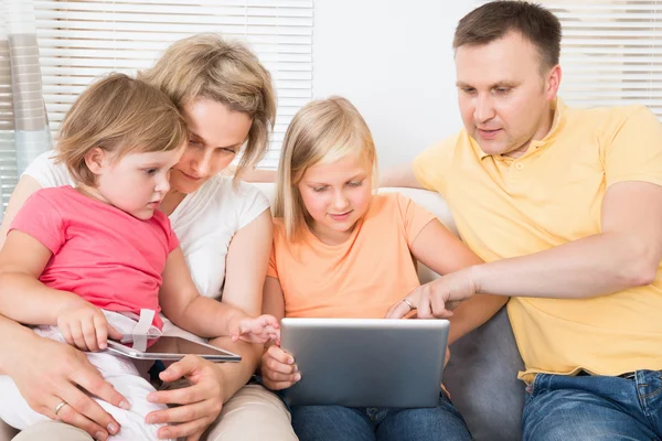 Familia joven usando tableta juntos — Foto de Stock