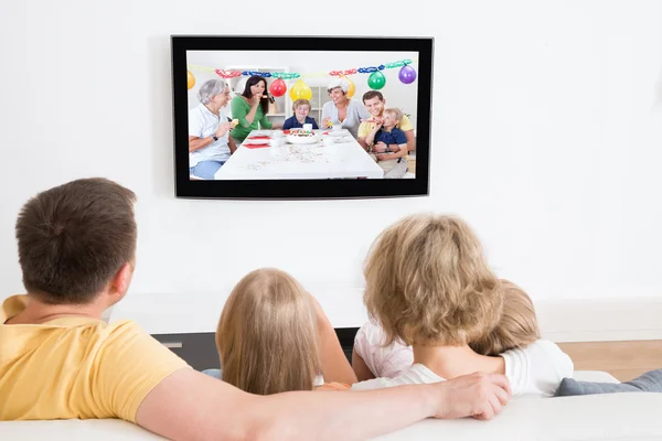 Joven familia viendo televisión juntos — Foto de Stock