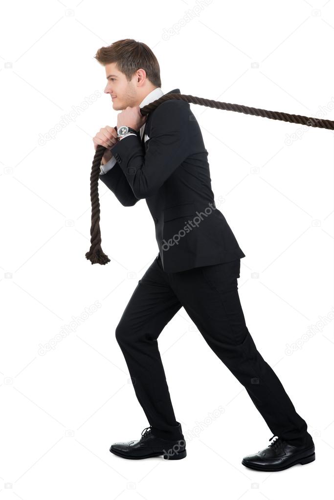 Side View Of Businessman Pulling Rope