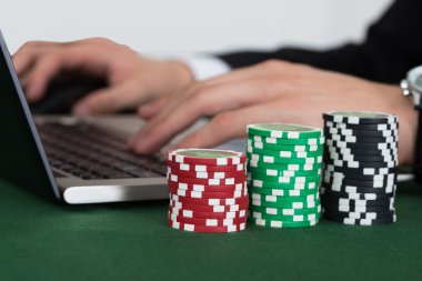 Laptop yanında yığılmış Casino fişi kullanarak