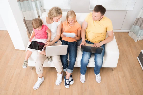 Família usando comprimidos e computadores — Stockfoto