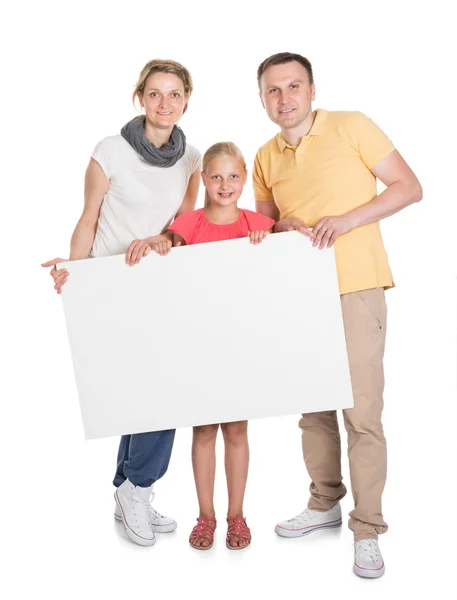 Feliz jovem família segurando banner — Fotografia de Stock