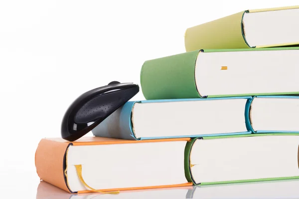 Computer mouse climbing books — Stock Photo, Image