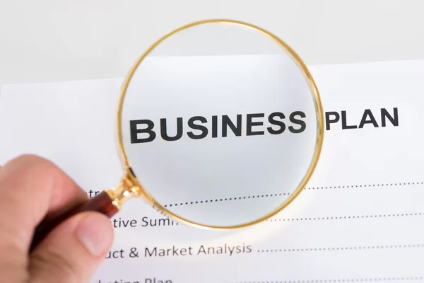 Magnifying glass and business plan — Stock Photo, Image