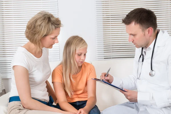 Médico con niño paciente y madre — Foto de Stock