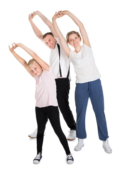 Jovem família fazendo exercícios de alongamento — Fotografia de Stock