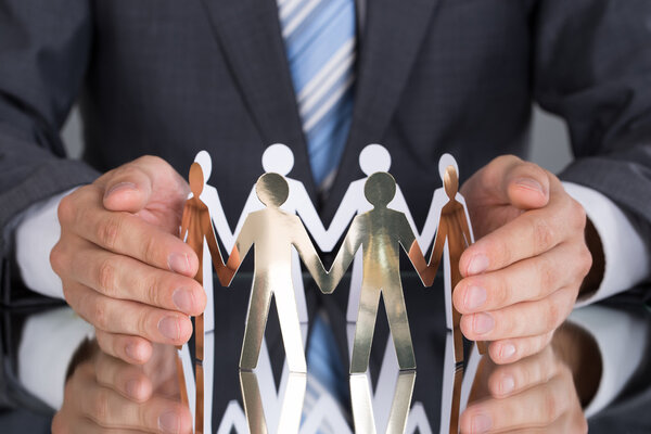 Бизнесмен, защищающий бумажных людей
