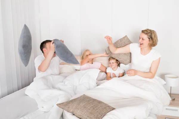 Família tendo travesseiro luta na cama — Fotografia de Stock