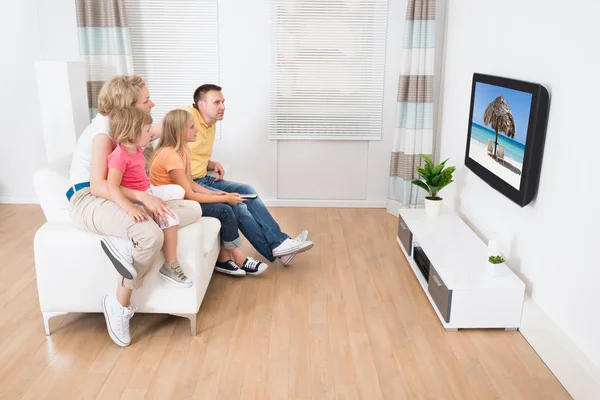 Família jovem assistindo TV juntos — Fotografia de Stock