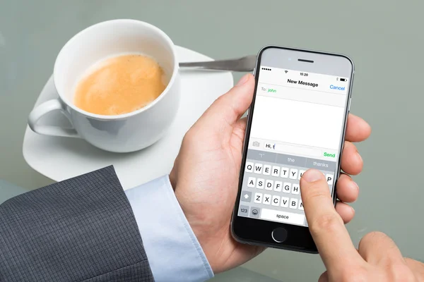 Текстовые сообщения бизнесмена на Apple iPhone 6 — стоковое фото