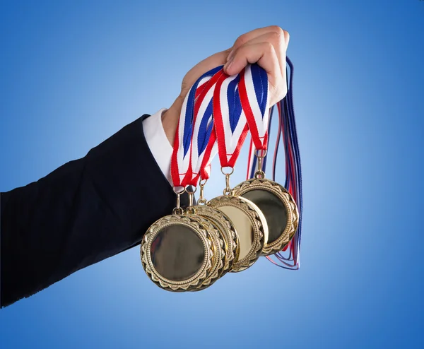 Affärsmannens Hand innehav medaljer — Stockfoto