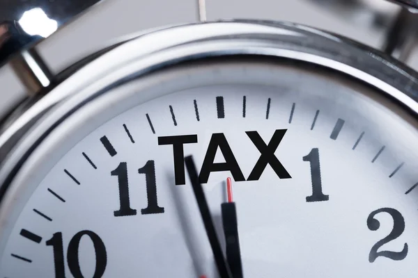 Тревожные часы показывают прибытие налогов — стоковое фото