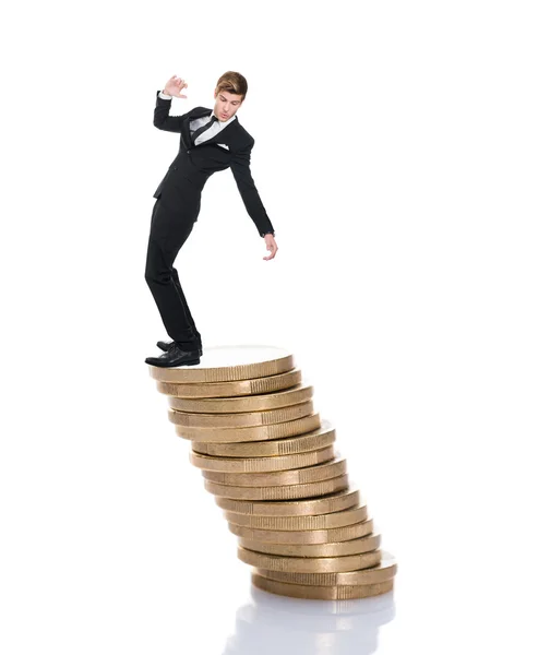 Бизнесмен балансирует на монетах — стоковое фото