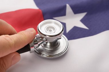 Stetoskop Amerikan bayrağı üzerinde tutan el