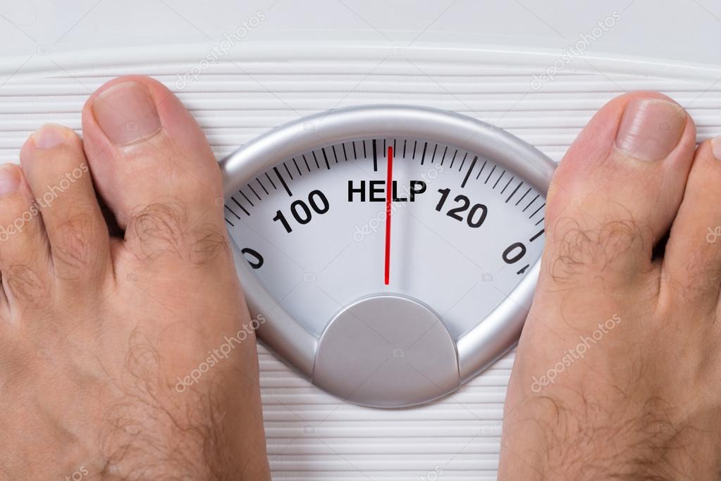 Man On Weight Scale Indicating Help Stock Photo by ©AndreyPopov 62703757