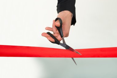 Businessman Cutting Red Ribbon With Scissors clipart
